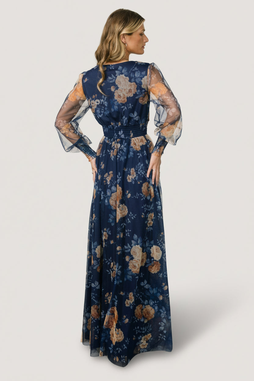 Detail shot of sleeve cuff and smocking with golden floral print on blue tulle, showing fabric texture, stretch and stitching quality.