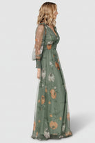 Model movement shot in Layla Tulle Maxi Dress dusty olive floral, emphasizing flowing tulle skirt, deep V-neck and bump-friendly silhouette.