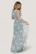 Side view of Layla tulle maxi in light blue floral showing sleeve silhouette, smocked cuff detail, and layered tulle panels on the skirt.