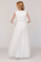 Back view of Layla Tulle Maxi Dress in white on model, displaying the flowing tulle skirt, raw hem and overall maxi length.
