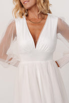 Three-quarter view of Layla Tulle Maxi Dress in white, highlighting sheer long sleeves, delicate tulle overlay and natural movement of the skirt.