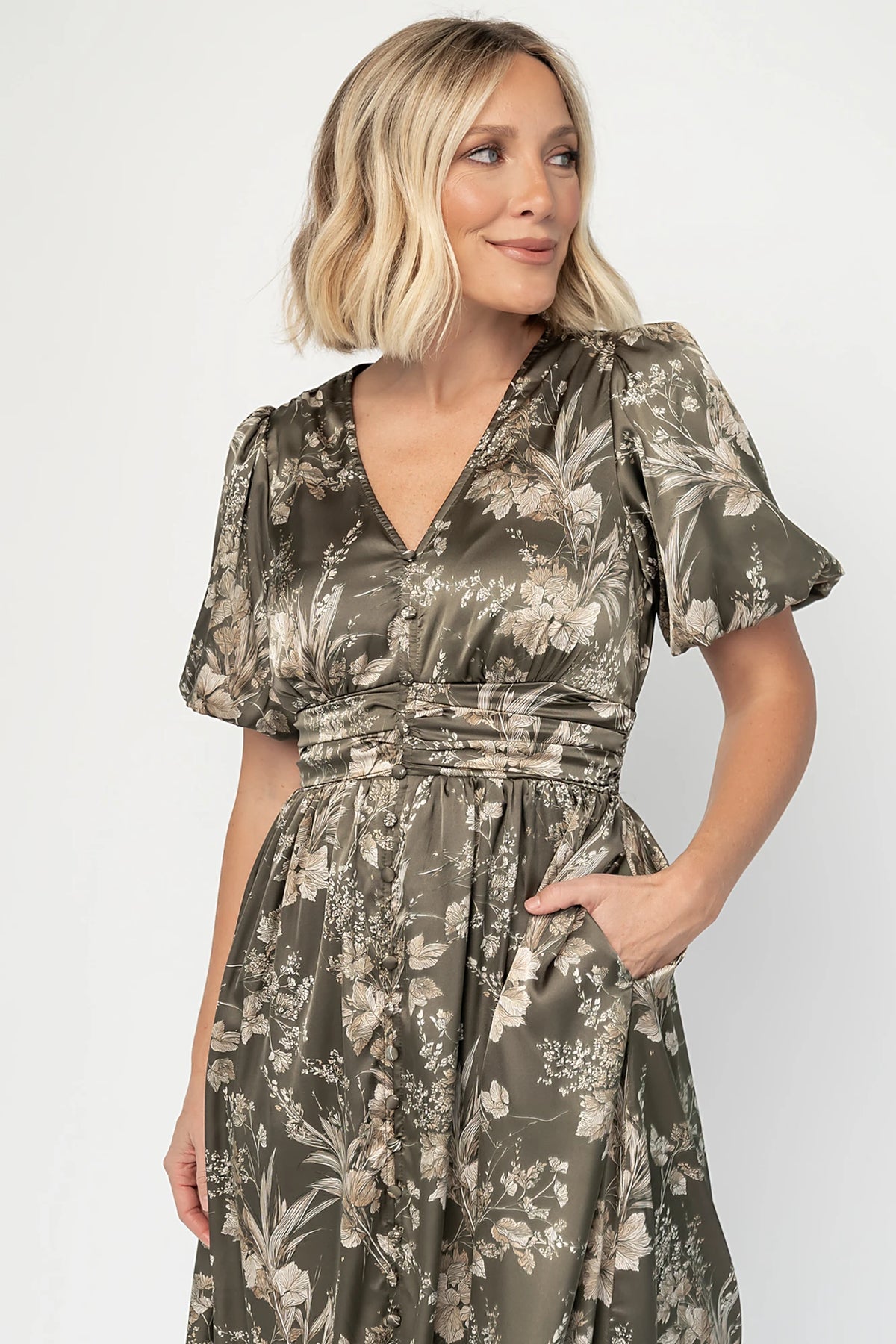 Lilibet Satin Dress in Olive Floral with V-neckline, short sleeves, faux front buttons, gathered waist, and satin finish.