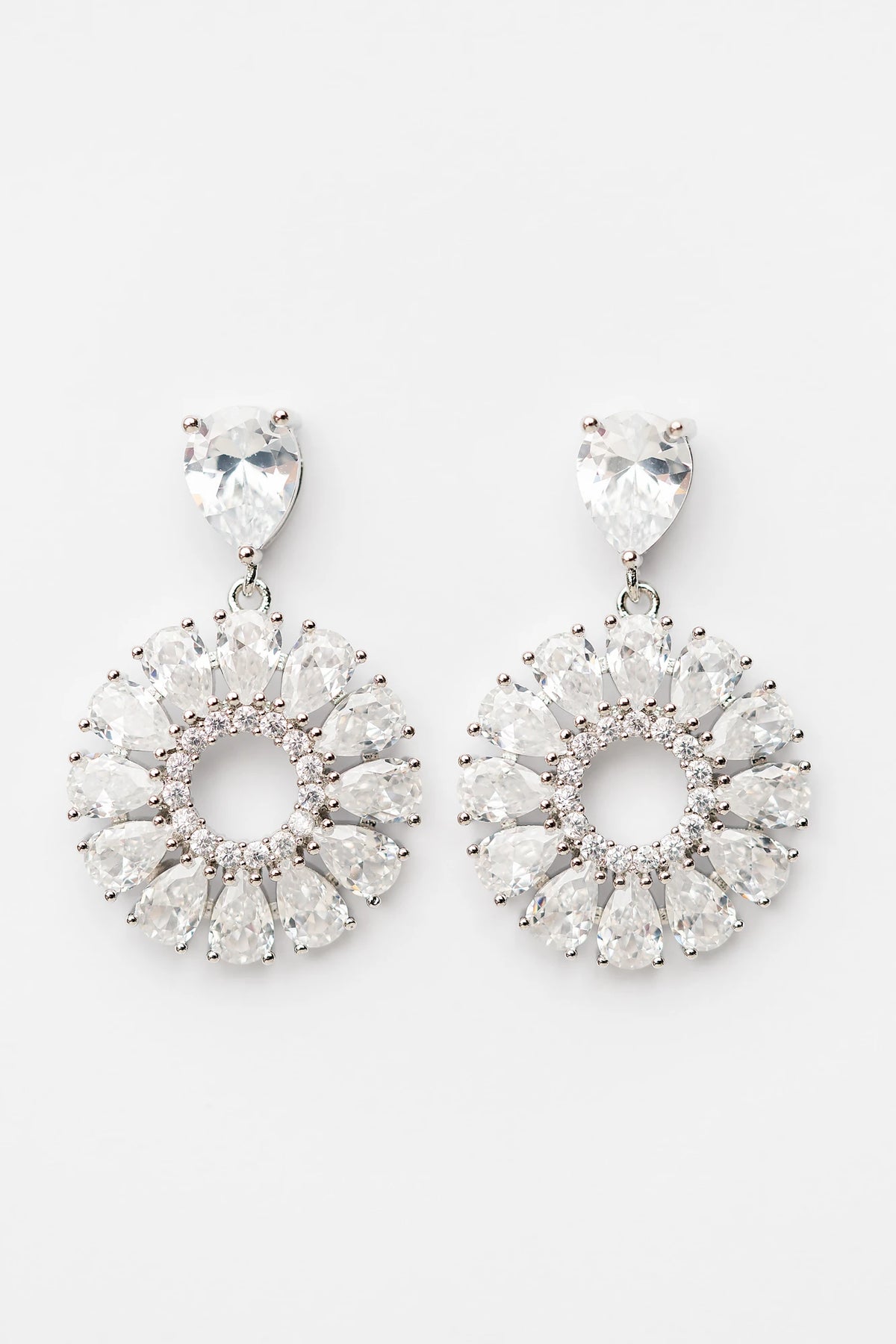 Lisandra Cluster Drop Earrings in Silver with teardrop studs, clear faceted stones, and circular cluster drops.