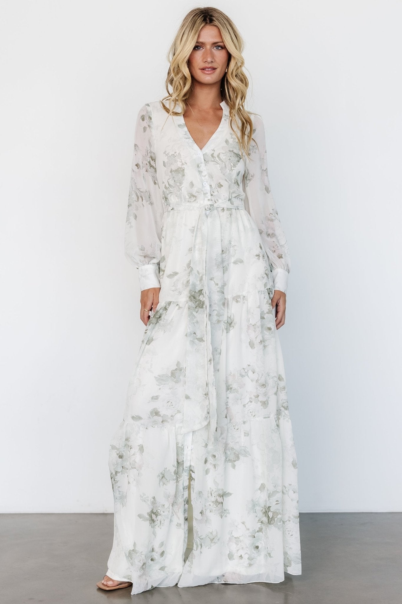 Front view of Lizette Sage Print maxi dress showing mandarin collar, v-neckline, functional front buttons, self-tie sash, and tiered skirt.