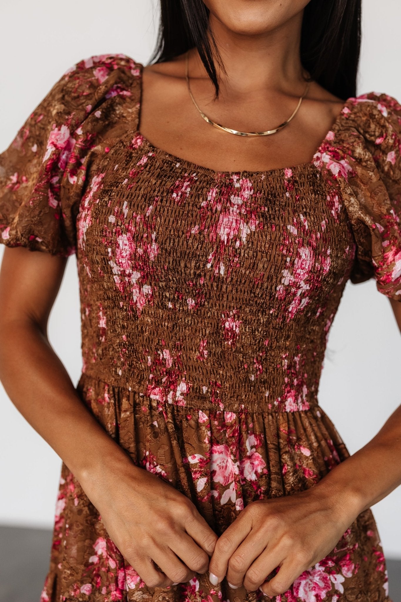 Three-quarter view of Lizzy midi dress in copper and pink floral print; puffed short balloon sleeve and embroidered overlay visible.