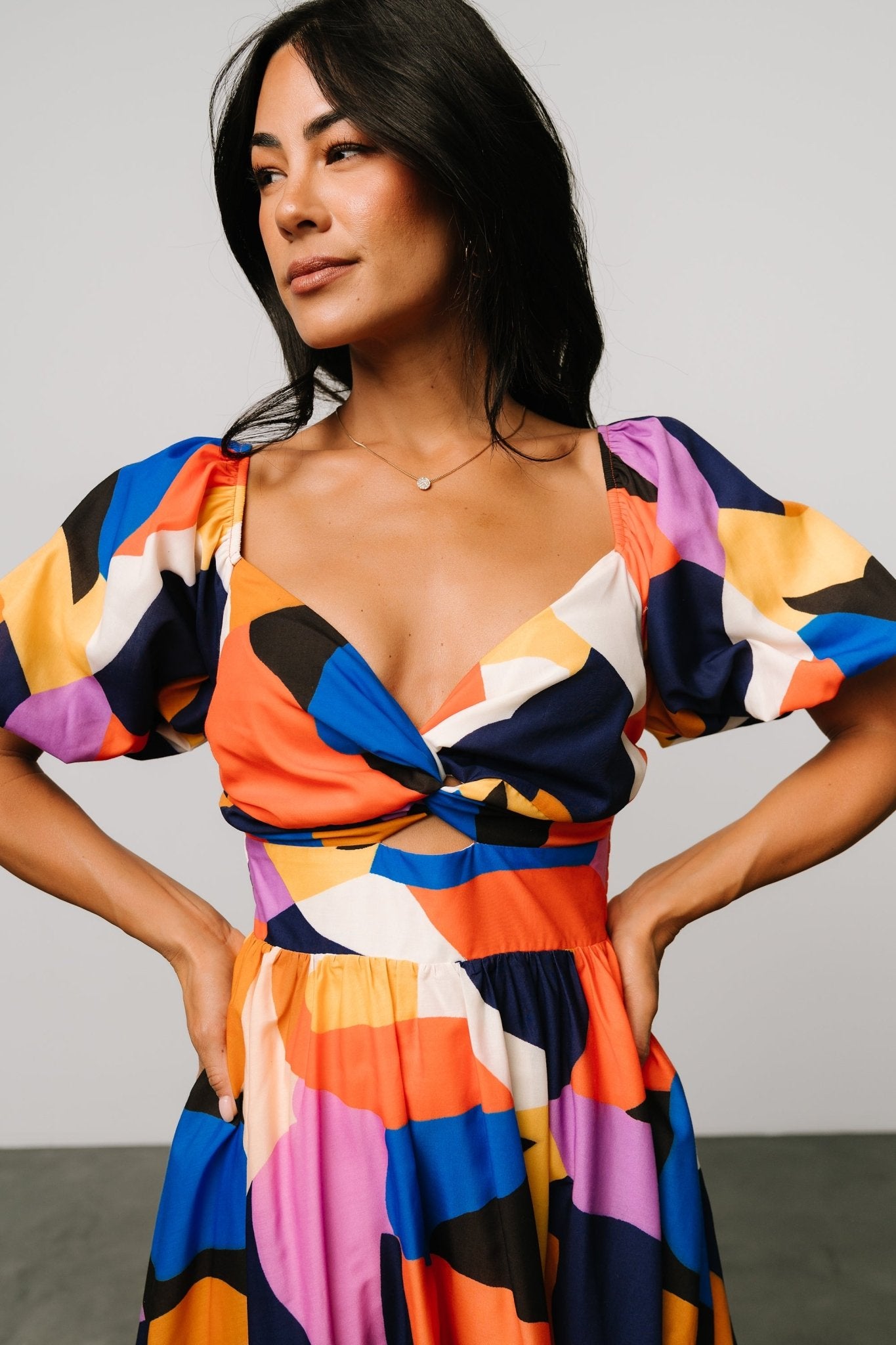 Close-up of smocked bodice and sweetheart neckline on rust and navy multi abstract print midi dress.