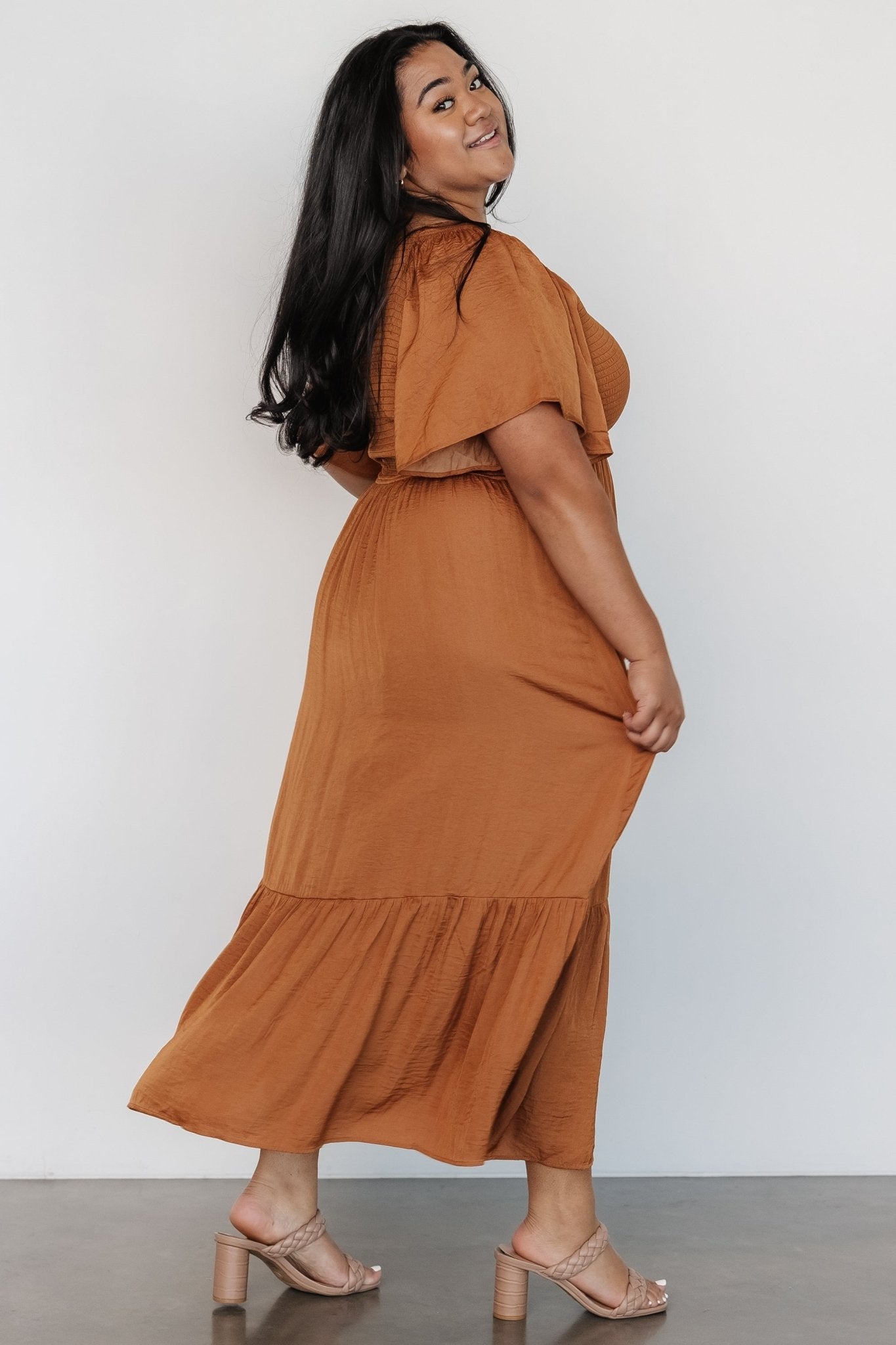 Fabric close-up showing satin-like texture and subtle sheen of the dark copper polyester material.