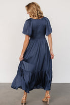 Detail shot of satin-like polyester fabric showing subtle sheen and soft drape of the Lovell smocked midi dress.