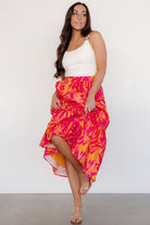 Back view showing the smocked waistband of the Luana skirt in orange and fuchsia, highlighting comfortable stretch and fit.