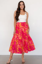 Close-up of the orange and fuchsia leaf print and lightweight cotton fabric texture on the Luana tiered skirt.