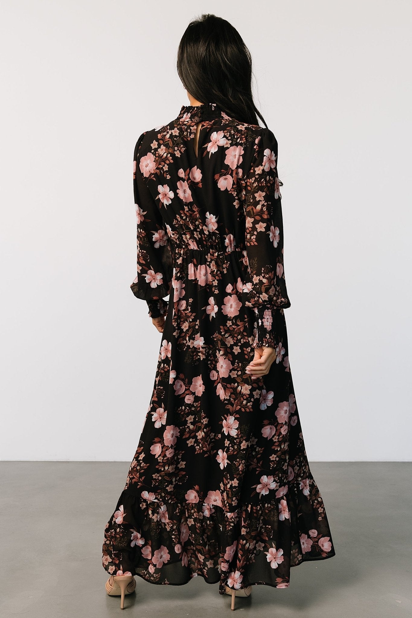 Styled outfit shot showing the black and mauve floral Luciana maxi dress paired with simple heels for an occasion-ready look.