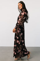 Close-up of smocked high neckline and ruffle cuff detail on the lightweight chiffon fabric with floral print.