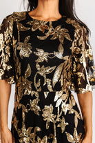Three-quarter angle of Lucy Sequin Dress highlighting gold sequin pattern on black tulle overlay and the soft drape of the lined skirt.