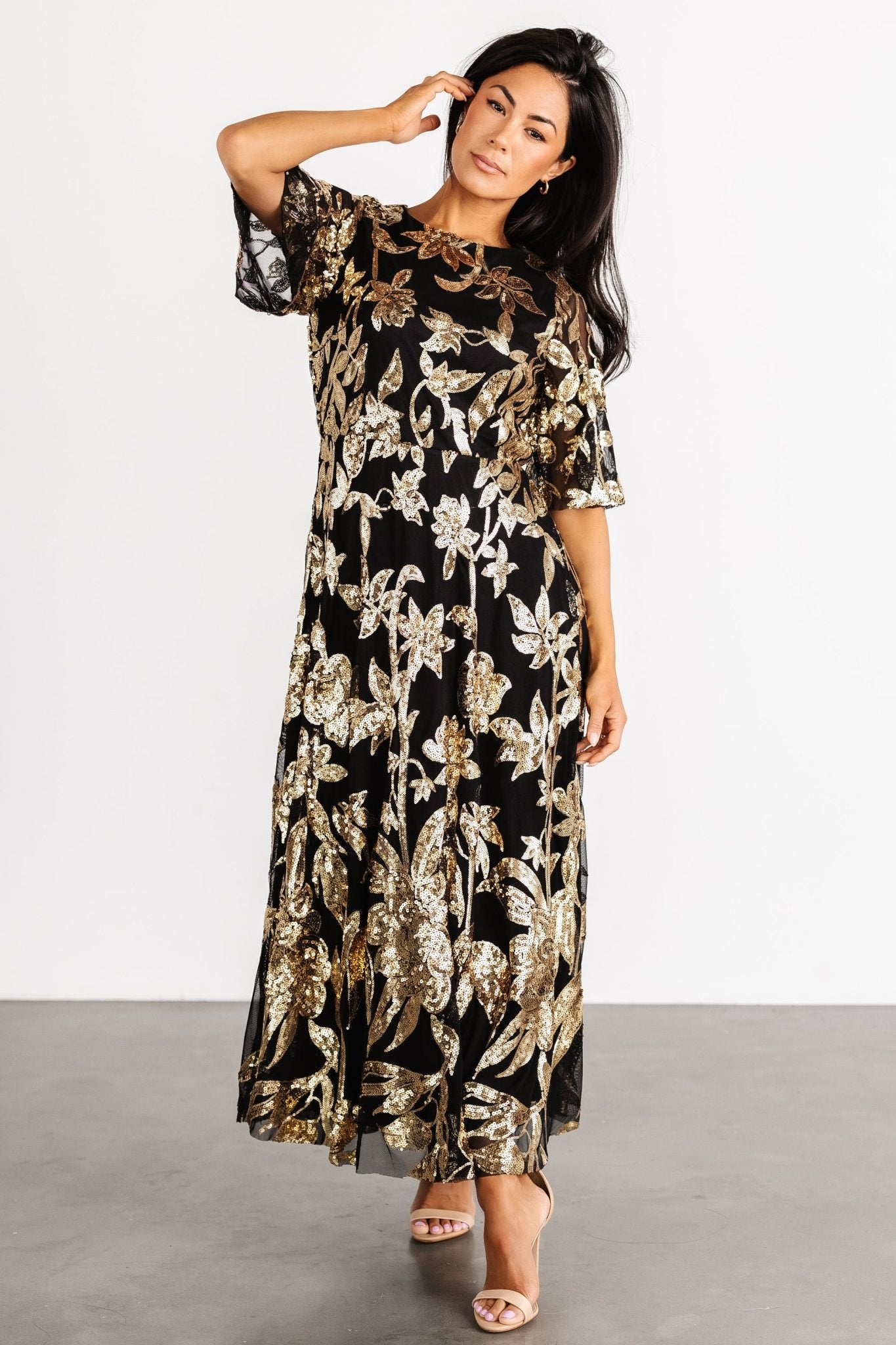 Full-length shot of the Lucy Sequin Dress illustrating the flowing silhouette, raw-hem skirt, and elegant movement when walking.
