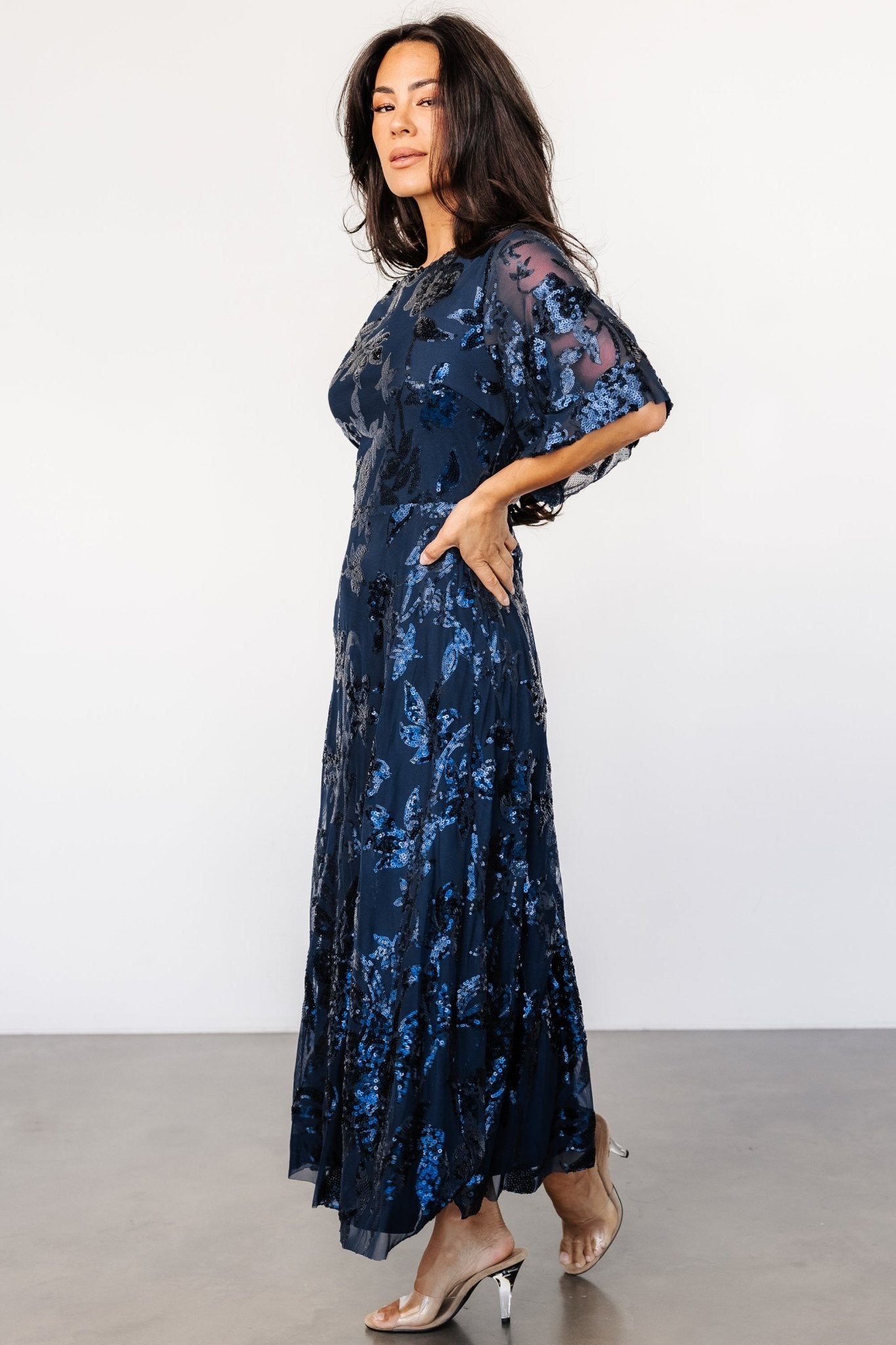 Back view highlighting the keyhole-and-button closure, elasticated waist, and the way the tulle drapes over the lined skirt.