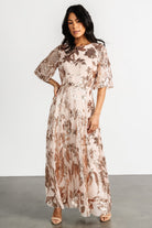 Side profile of the dress on a model, emphasizing the elastic waist, maxi length, and subtle shimmer of floral sequins.