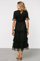 Back view of the black Lysandra Smocked Dot Dress showing keyhole and button closure, layered tulle, and the dress’s tiered silhouette.