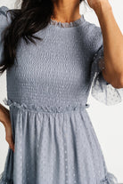 Three-quarter angle of Lysandra dress highlighting polka dot tulle overlay, short ruffle sleeves, and the flowing, tiered midi skirt with delicate ruffle edges.