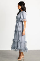 Back view of Lysandra dress displaying the keyhole and button closure, smocked waist detail, and the layered lining under the polka dot tulle.