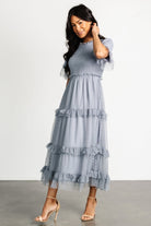 Close-up of the smocked bodice and high ruffle collar on the Dusty Slate Lysandra dress showing texture and dot pattern on the tulle overlay.