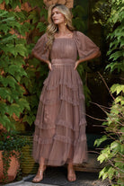Back and side view of dusty mink Magdalena Tulle Maxi Dress illustrating tiered ruffle skirt and soft drape of the tulle overlay.