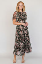 Back view showing round neckline and button-keyhole closure with delicate embroidery around the back and shoulder seams.