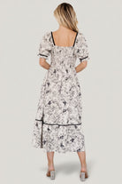 Side view of Mariana Midi Dress showing smocked back bodice, elastic at natural waist, hidden side pocket, and tiered midi hem.
