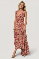 Full-length side view of Martina Maxi Dress in blush and red floral chiffon highlighting three-tiered skirt and soft ruffle trims.
