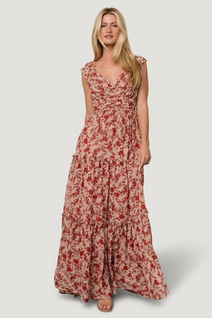 Model front view wearing Martina Maxi Dress in blush with red floral chiffon, wide V-neck and flutter sleeves, full maxi length.