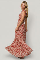 Back view of Martina Maxi Dress displaying smocked back bodice, elastic shoulder with ruffle, and tiered maxi skirt movement.