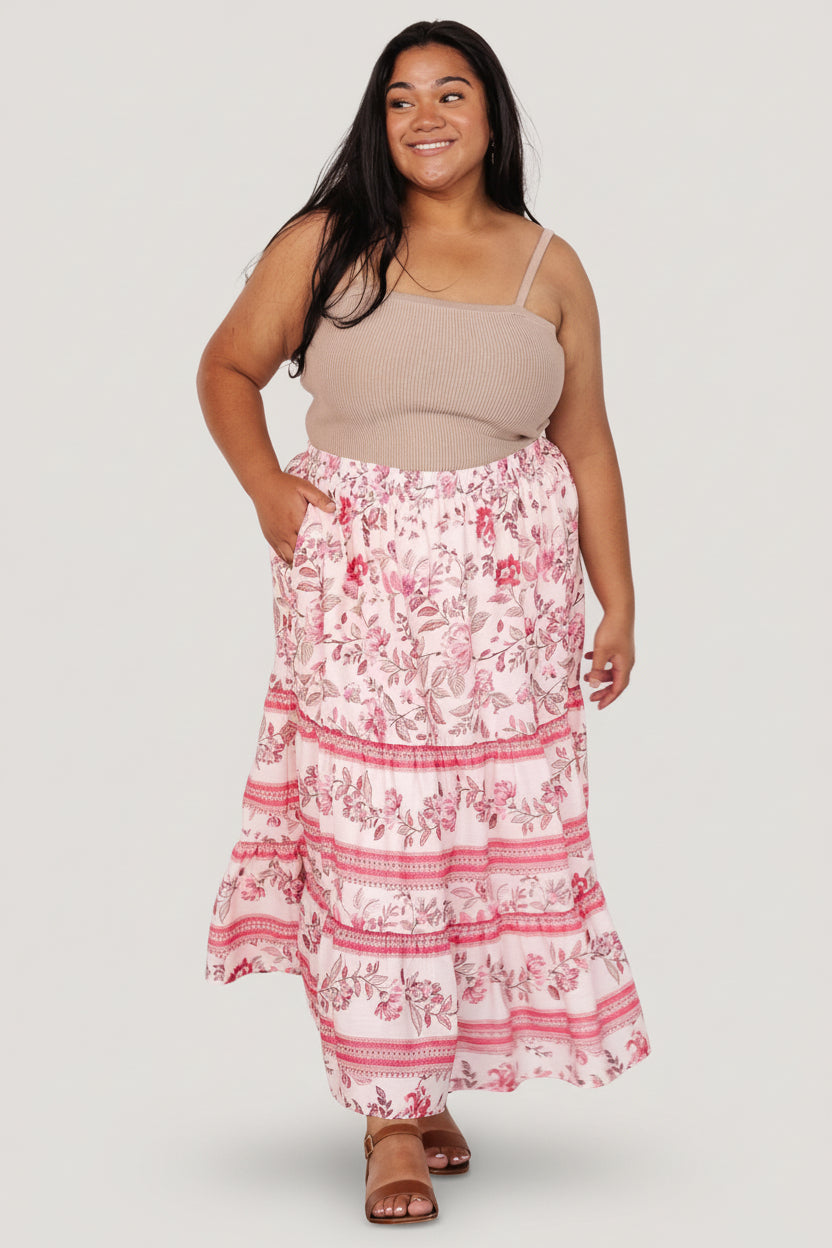 Close-up of Meg skirt fabric and print showing soft rayon drape, blush and pink floral details, and textured tier seams for movement.