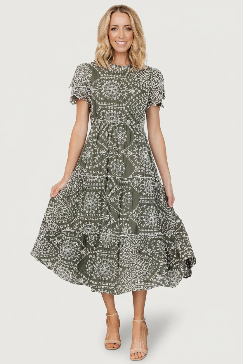 Model wearing Mirabel Eyelet Midi Dress in olive and white, showing fit at the waist, lined bodice, and midi length.