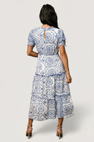 Side view highlighting the hidden side pocket and elastic waistband on the Mirabel midi dress with embroidered eyelet pattern.