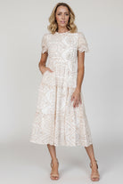 Side view of the midi dress showing the elastic waistband, tiered silhouette, and the placement of the hidden side pocket on the skirt.