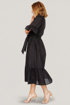 Side view of the Mirielle midi dress illustrating the comfortable A-line skirt and accessible side pockets.