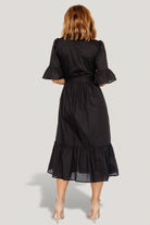 Model wearing the Mirielle black midi dress, showing fit through the shoulders and how the removable sash defines the waist.