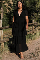 Back view of the black Montaigne ruffle maxi dress showing the smocked back and gentle gathering at the waist for flexible fit.