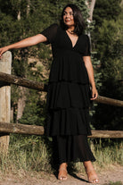 Detail shot of skirt ruffles and lining edge on the black Montaigne dress showing the layered chiffon construction and movement.