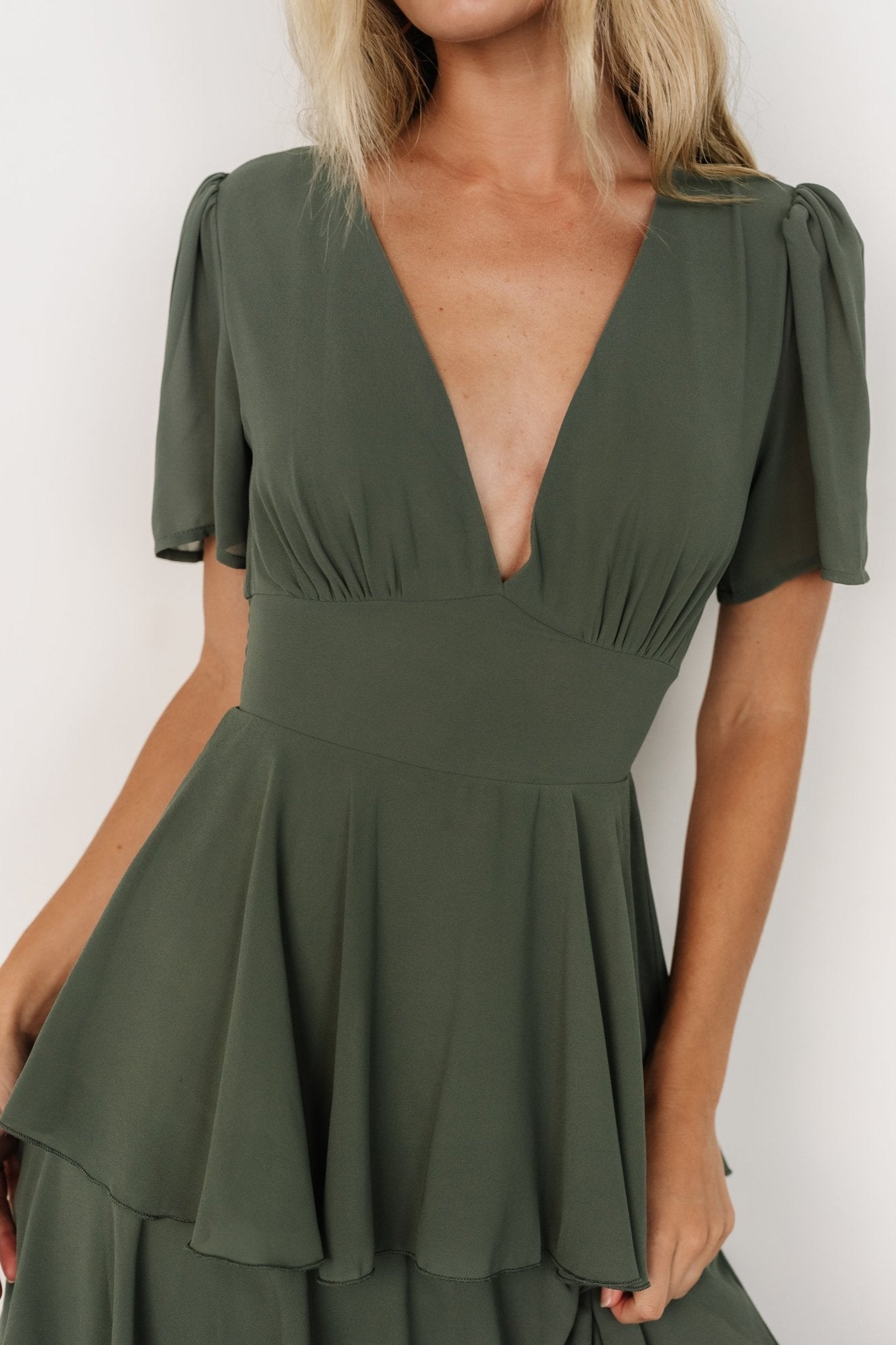 Studio shot of model wearing the Dark Sage Montaigne dress showing smocked back shaping and contouring underbust combined with flowing chiffon tiers.