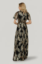 Model photo highlighting round neckline, fitted bodice, and contrast between lined body and sheer sequin sleeves for evening wear.