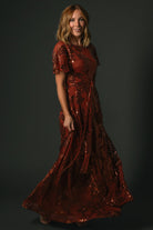 Detail shot of Muse Sequin Maxi Dress cinnamon waist sash and fabric texture emphasizing tailored waist definition and sequin embellishment.