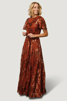 Rear view of Muse Sequin Maxi Dress in cinnamon showing keyhole and button closure at back and gentle drape of the maxi skirt.