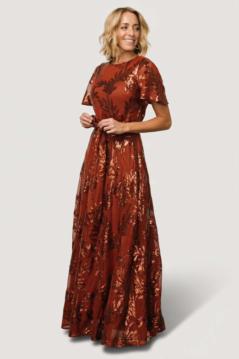 Rear view of Muse Sequin Maxi Dress in cinnamon showing keyhole and button closure at back and gentle drape of the maxi skirt.