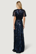 Back view of the navy sequin maxi showing keyhole and single-button closure, sequin placement, and how the sash ties at the waist.