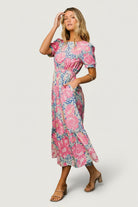 Studio close-up showing the blue and pink floral print, fabric texture, and partial lining detail on the tiered midi dress.