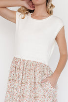 Close-up of sweater-knit bodice and rolled cuff on short cap sleeve, ivory knit contrasted with floral skirt fabric.