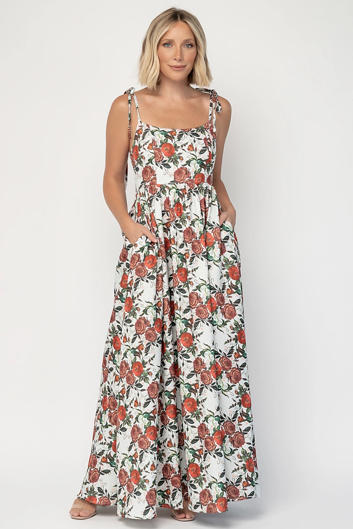 Nadine Maxi Dress in Red + Green Floral with tie straps, smocked back, flowing skirt, and left leg slit.