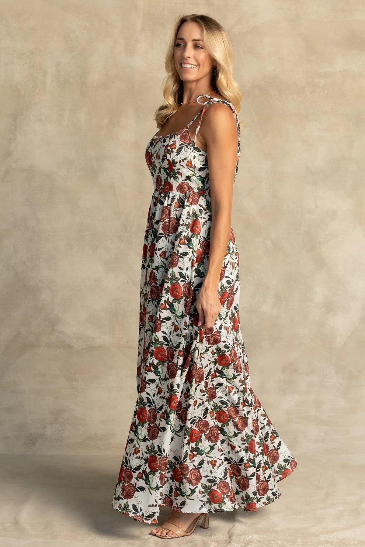 Nadine Maxi Dress in Red + Green Floral with tie straps, smocked back, flowing skirt, and left leg slit.