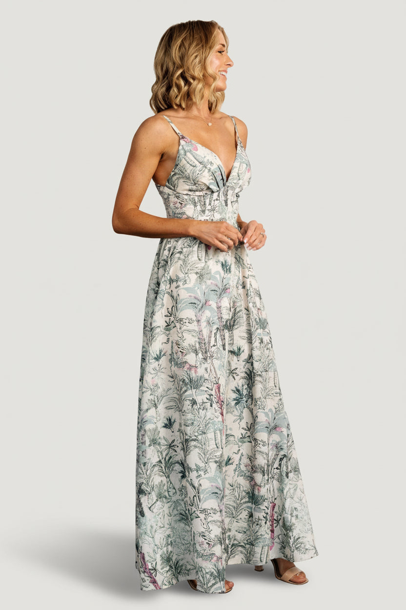 Model wearing Naia Maxi Dress full-length, natural background with sage print, styled for special occasions with relaxed, elegant movement.