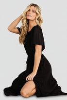 Back view showing keyhole button closure, elasticized back waist, and full-length chiffon skirt with elegant sweep.